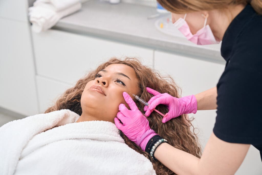 A woman receiving Botox injections in a clinic, highlighting the need for a skilled injector to ensure safe and effective cosmetic results.